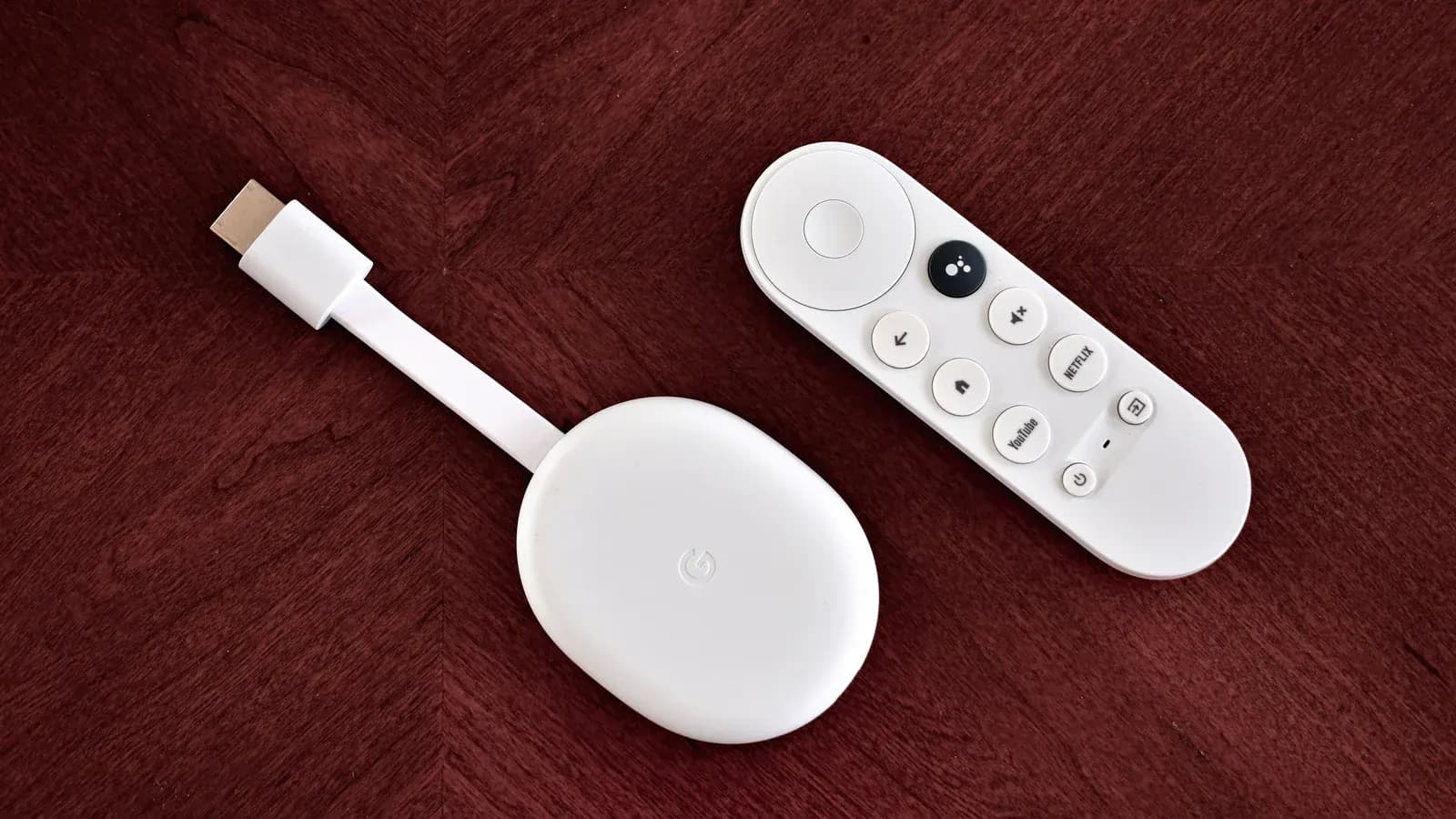 Chromecast with Google TV streaming device and remote on a wooden table