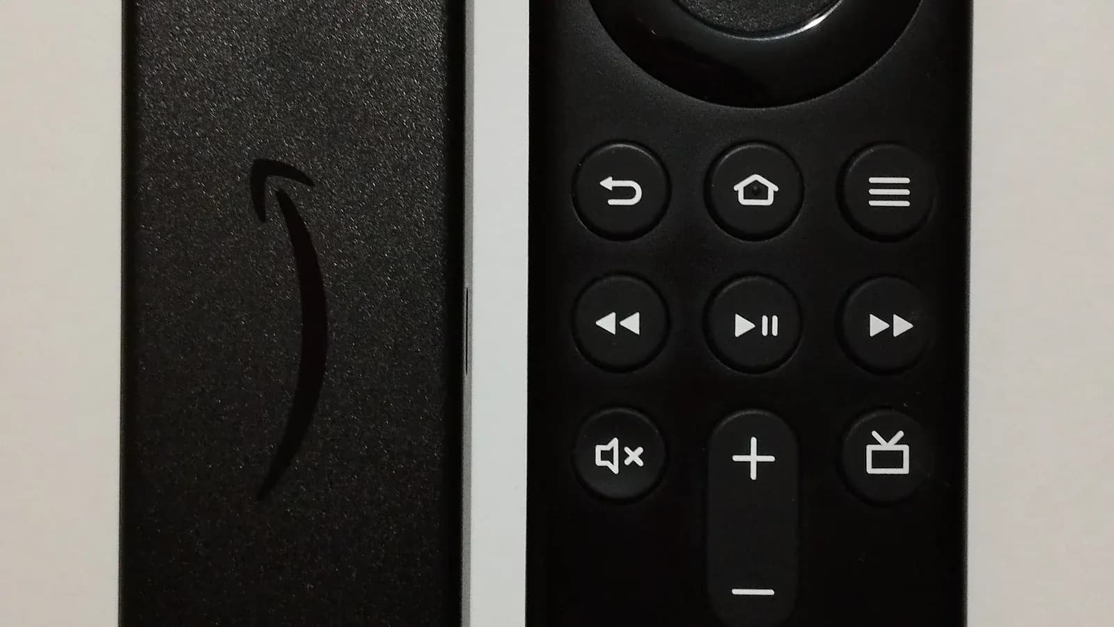 Amazon Fire TV streaming stick and remote control on a plain background