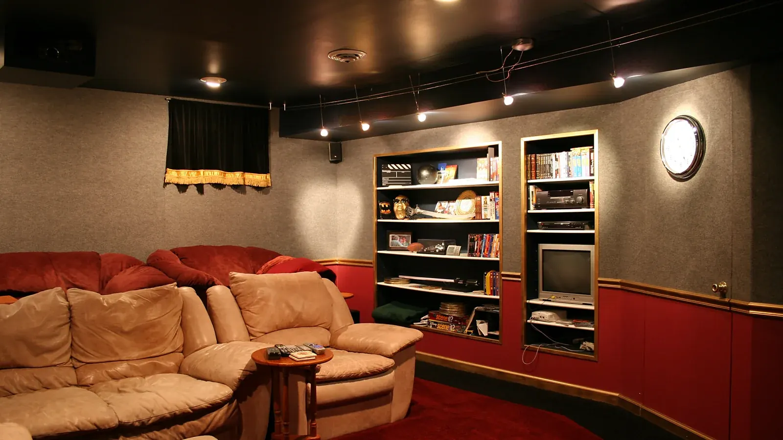 Home theater room with shelves of movies next to a television